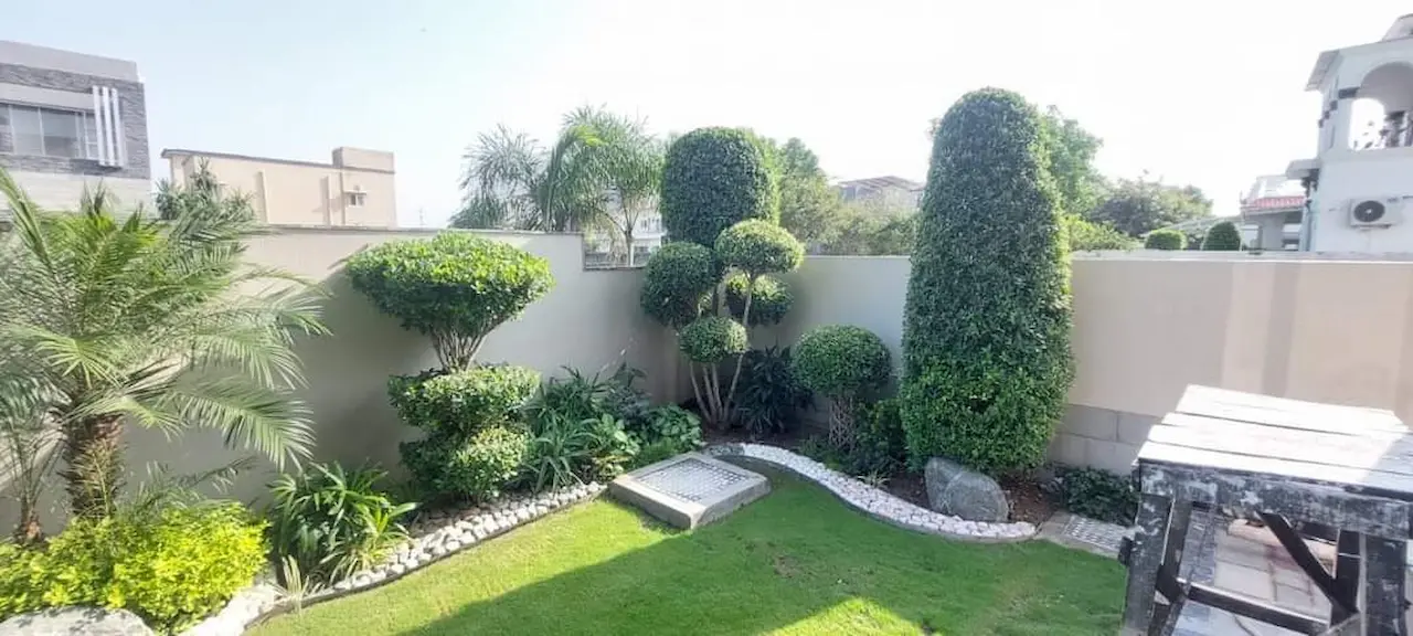 Secret garden with a central lawn and flower beds